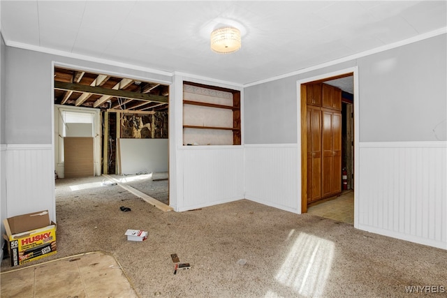 empty room with ornamental molding and light colored carpet