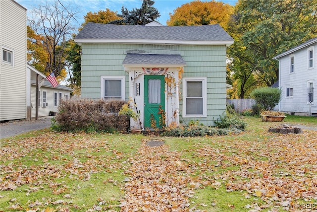 bungalow-style home with a shed and a front lawn