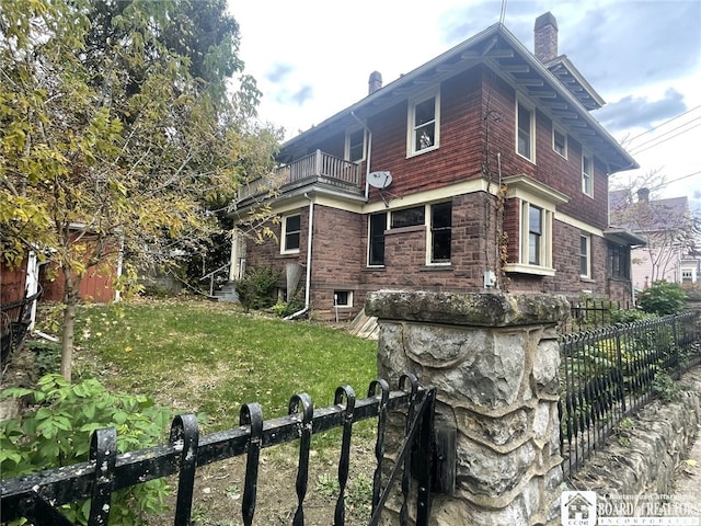 view of home's exterior featuring a lawn and a balcony