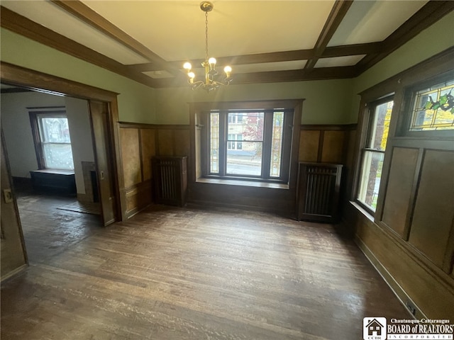 unfurnished dining area with dark hardwood / wood-style floors, a healthy amount of sunlight, beamed ceiling, and coffered ceiling