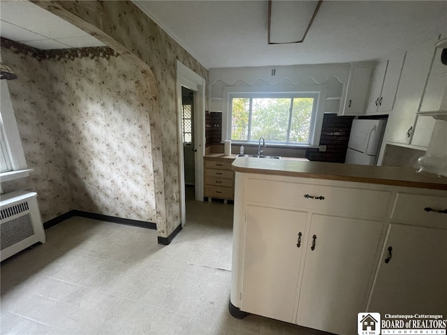 kitchen with white cabinets, white fridge, and sink