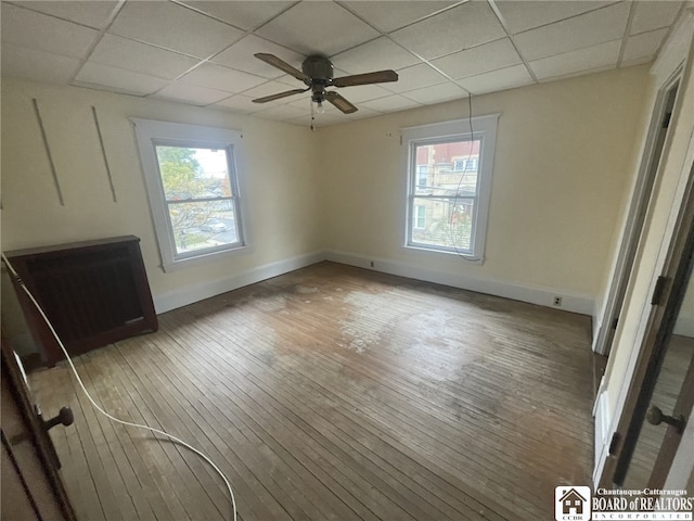 interior space with a paneled ceiling, hardwood / wood-style flooring, and ceiling fan