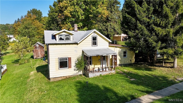 back of house with a porch and a yard