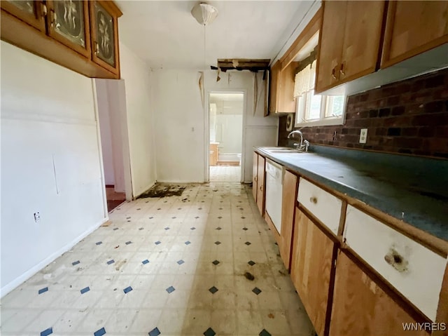 kitchen featuring white dishwasher, sink, and backsplash