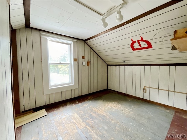 bonus room featuring dark hardwood / wood-style flooring, wooden walls, and vaulted ceiling