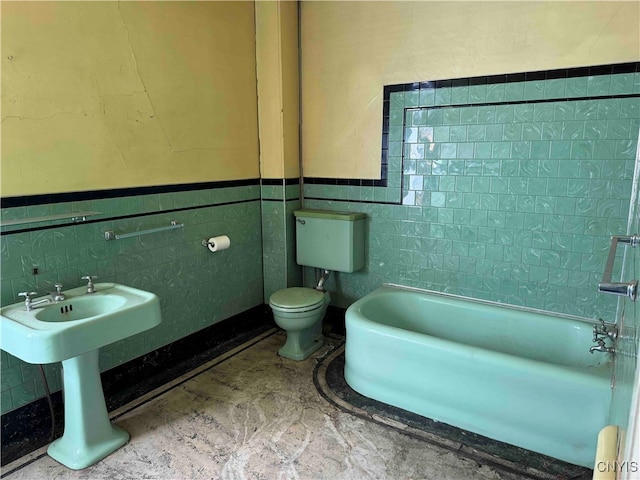 bathroom featuring toilet and tile walls