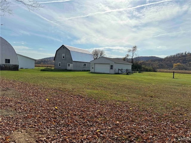 view of yard featuring a mountain view, an outdoor structure, and a garage