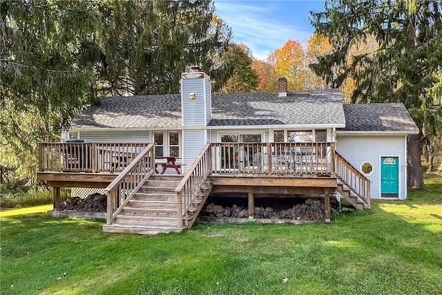 rear view of house with a deck and a lawn
