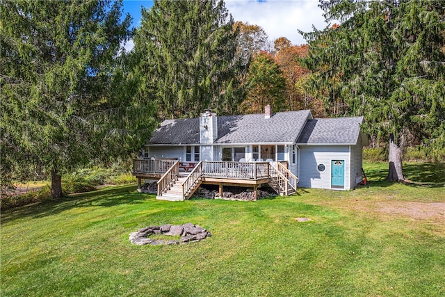 back of property with a wooden deck and a lawn
