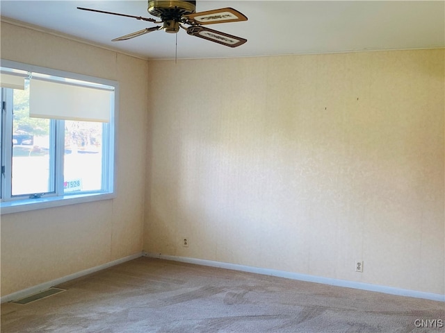 spare room with crown molding, light colored carpet, and ceiling fan