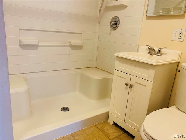 bathroom featuring vanity, toilet, and tiled shower