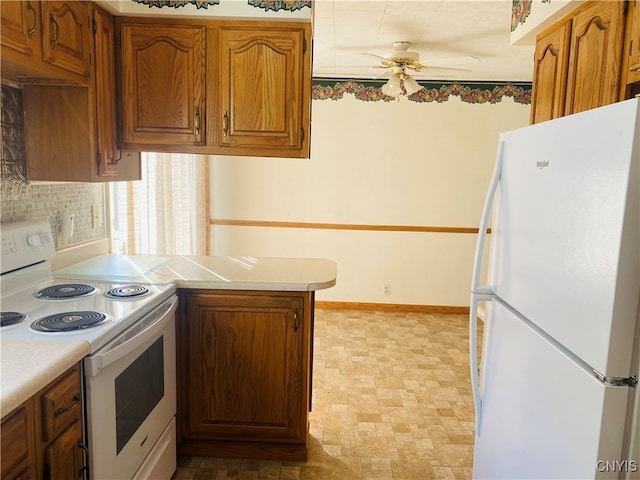 kitchen featuring kitchen peninsula, ceiling fan, white appliances, and tasteful backsplash