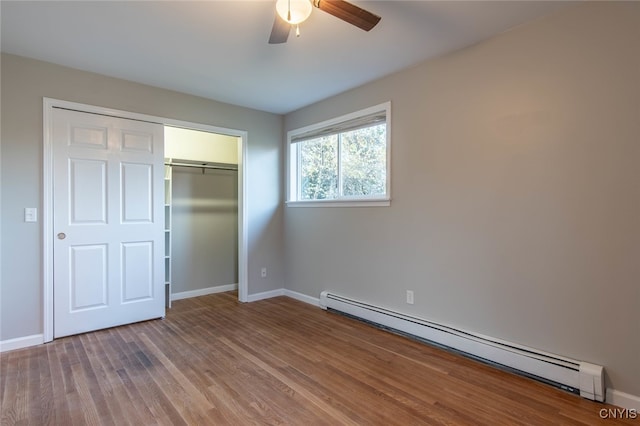 unfurnished bedroom featuring a closet, ceiling fan, wood-type flooring, and baseboard heating