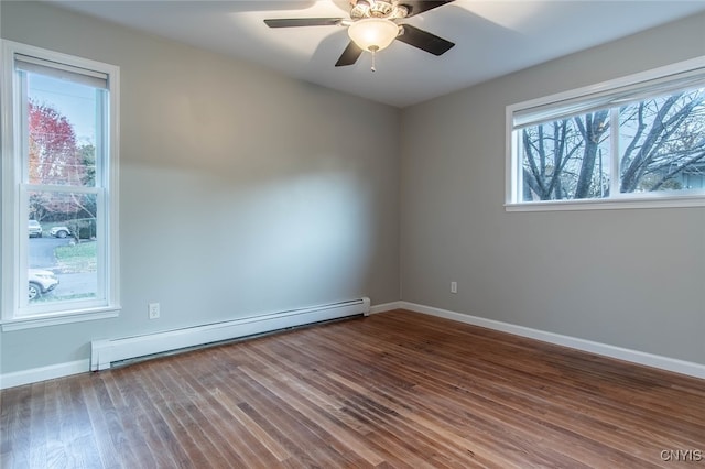 spare room featuring a baseboard heating unit, ceiling fan, and dark hardwood / wood-style flooring