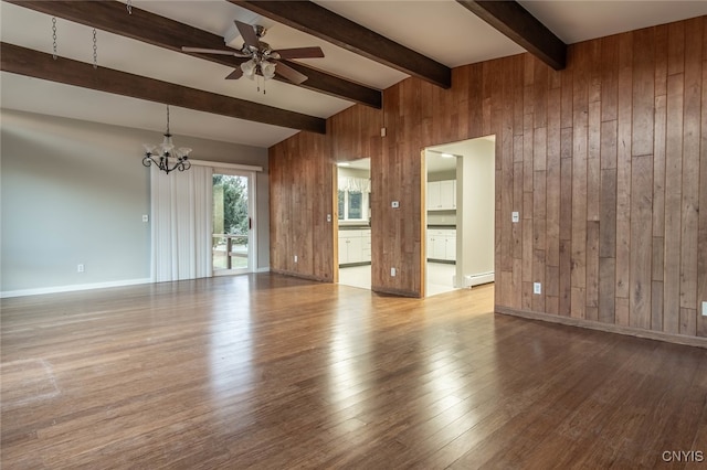 spare room featuring light hardwood / wood-style floors, baseboard heating, beamed ceiling, and wooden walls