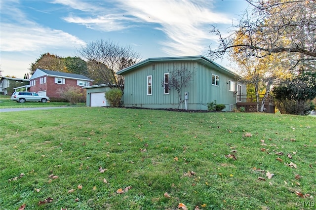 view of side of home featuring a lawn and a garage