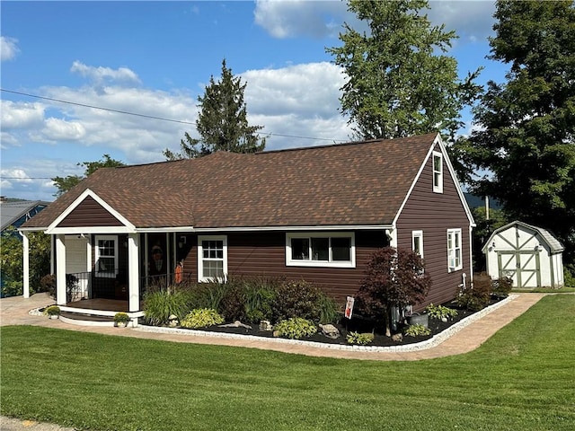 view of front of property with a front lawn, covered porch, and a shed