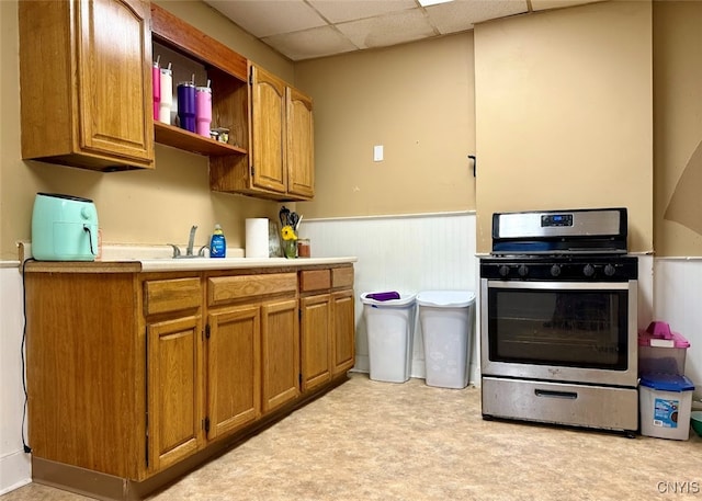 kitchen with sink, stainless steel range oven, and a drop ceiling