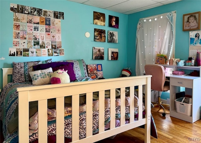 bedroom featuring hardwood / wood-style flooring and a drop ceiling