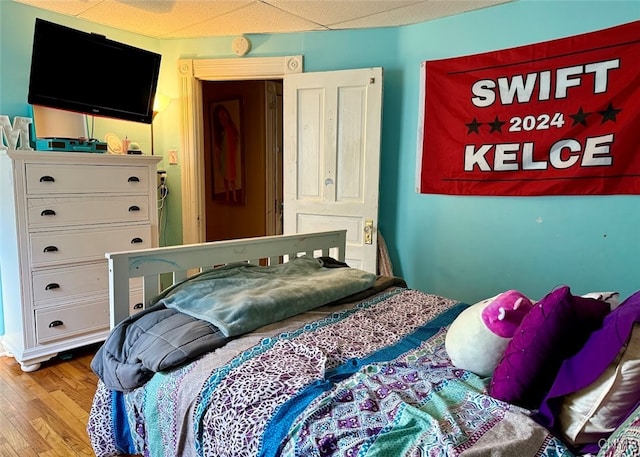 bedroom featuring a paneled ceiling and light wood-type flooring