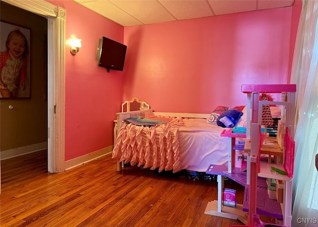 bedroom with hardwood / wood-style flooring and a paneled ceiling