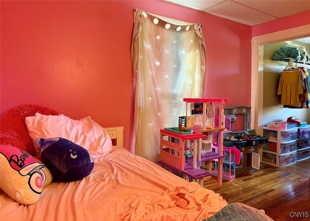 bedroom featuring a paneled ceiling and wood-type flooring