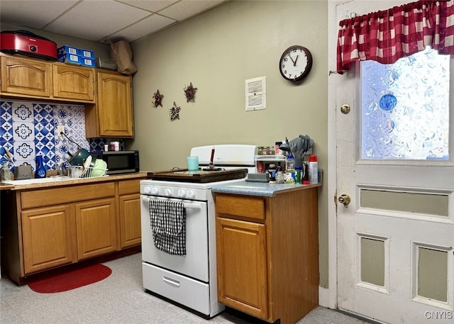 kitchen with a drop ceiling and white gas stove