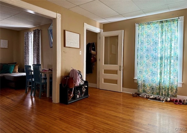 misc room with a healthy amount of sunlight, hardwood / wood-style flooring, and a drop ceiling