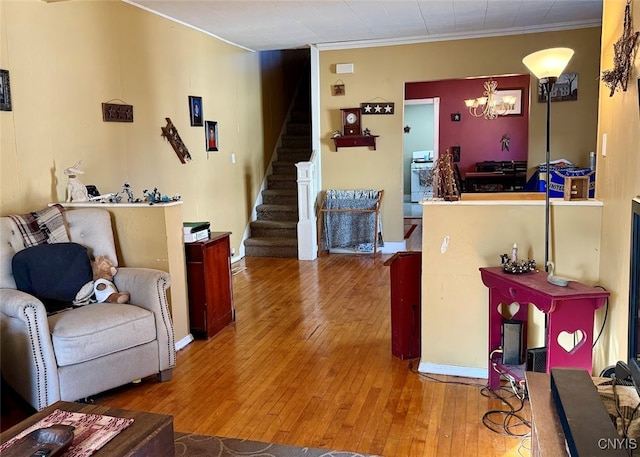 living room with ornamental molding, hardwood / wood-style floors, and a chandelier