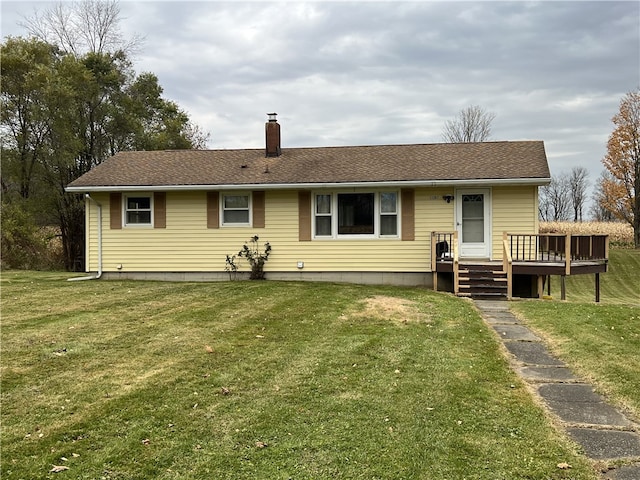 back of house featuring a deck and a lawn