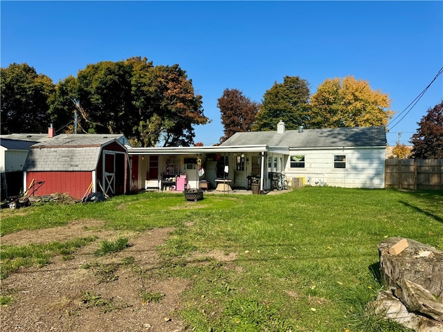 rear view of house featuring a storage shed, a yard, and a patio area