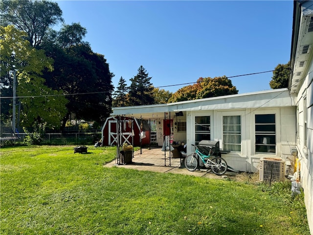 view of yard with central AC, a storage shed, and a patio