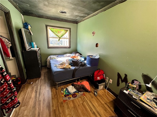 bedroom with crown molding and wood-type flooring