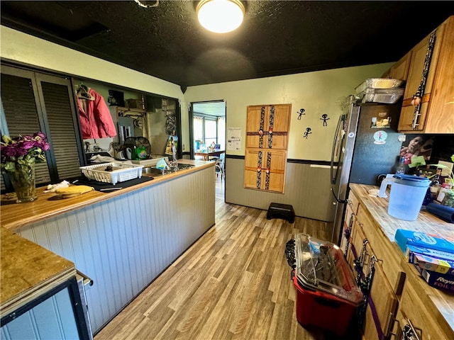 kitchen with a textured ceiling and light hardwood / wood-style flooring