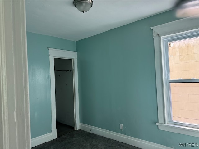 unfurnished bedroom with dark colored carpet