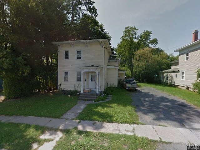 italianate-style house featuring a front lawn