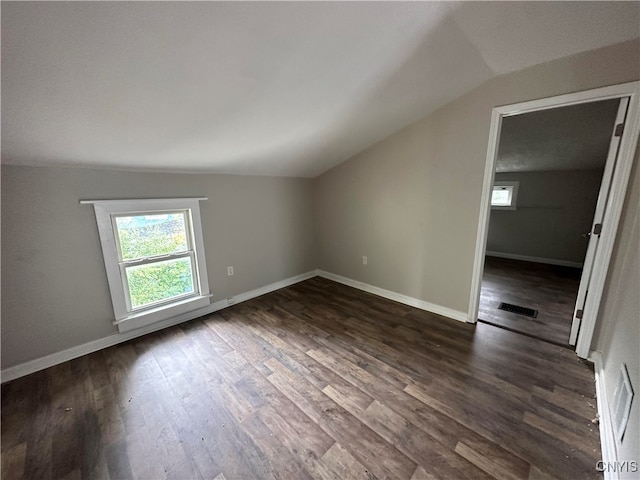 additional living space featuring vaulted ceiling and dark hardwood / wood-style floors