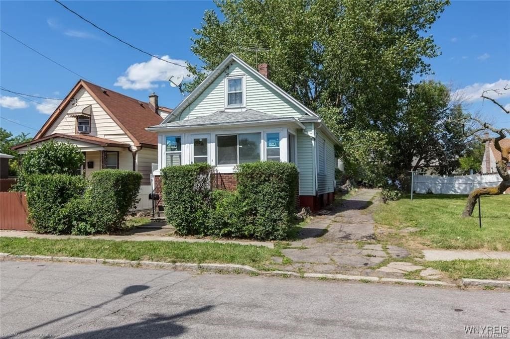 bungalow-style home with a front yard