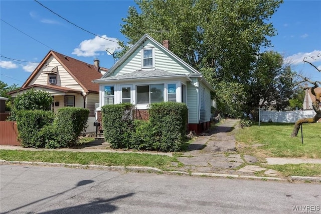 bungalow-style home with a front yard