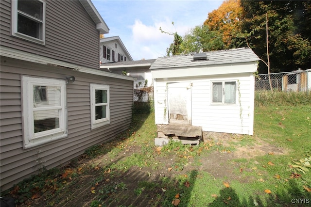 rear view of house with an outdoor structure and a yard