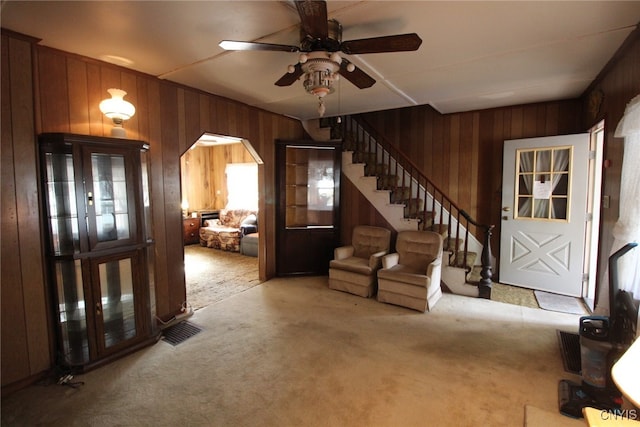 interior space featuring wooden walls and ceiling fan