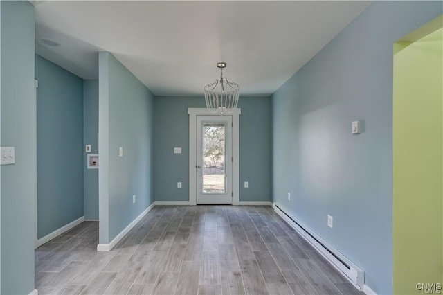 foyer entrance featuring hardwood / wood-style floors, a baseboard radiator, and a notable chandelier