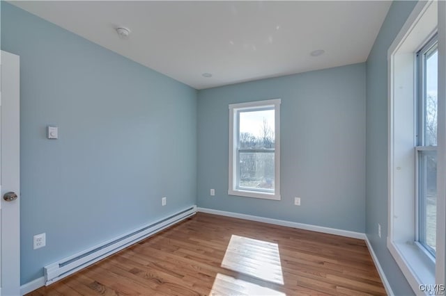 empty room featuring light hardwood / wood-style floors and a baseboard heating unit