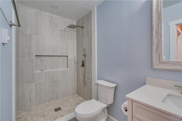 full bathroom featuring vanity, toilet, and tiled shower