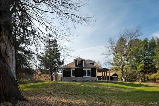 back of house featuring a lawn and roof with shingles