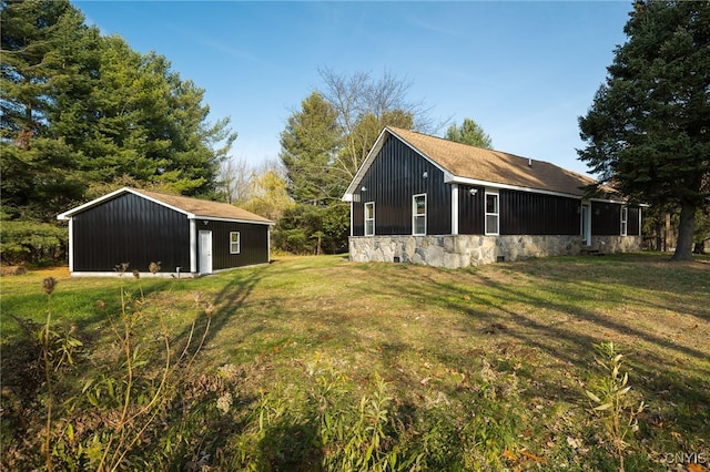 view of side of property featuring an outdoor structure and a yard