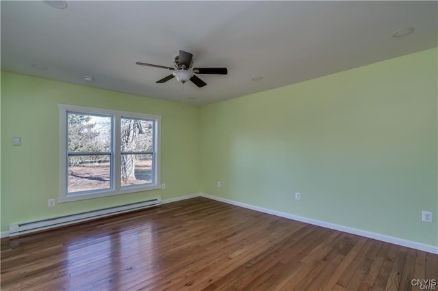 empty room featuring dark hardwood / wood-style floors, ceiling fan, and a baseboard heating unit