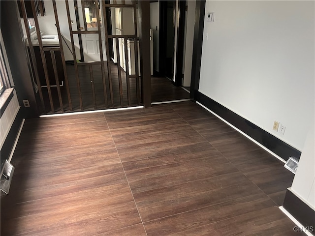 unfurnished room featuring dark wood-type flooring