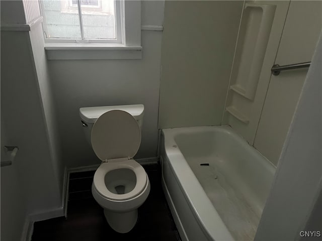 bathroom featuring a tub and toilet