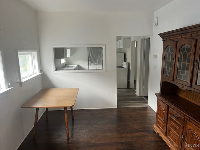 corridor with dark wood-type flooring and washer / clothes dryer